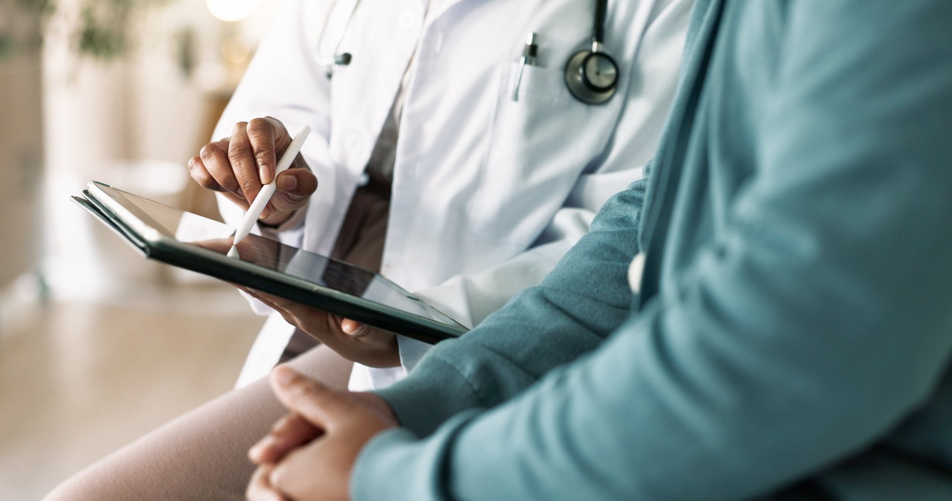 Doctor, hands and tablet with patient for consultation, medical advice or procedure at clinic